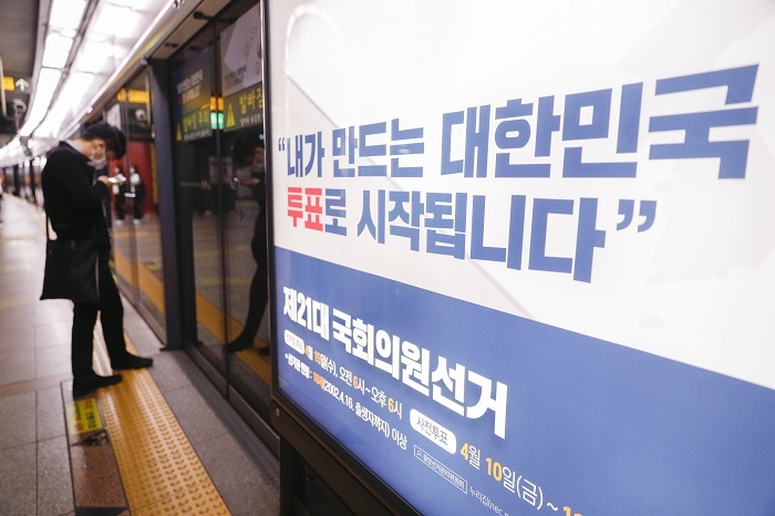 마스크를 착용한 시민이 15일 서울 중구 지하철 3호선 충무로역에 설치된 제21대 국회의원 총선거 홍보물 옆에서 열차를 기다리고 있다. (사진/뉴시스)
