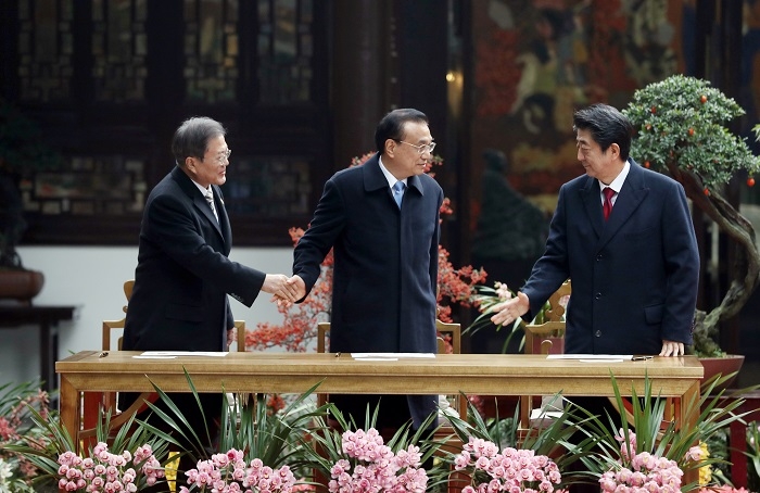 문재인 대통령과 리커창 중국 국무원 총리, 아베 신조 일본 총리가 지난해 12월 24일 중국 쓰촨성 청두 두보초당에서 한중일 협력 20주년 기념 봉투 서명식에 앞서 인사를 나누는 모습.(사진/뉴시스)