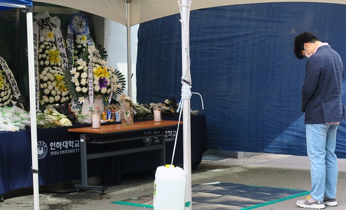 18일 오전 피해 여성이 발견된 인천 미추홀구 용현동 인하대학교의 한 단과대학 건물 앞 추모공간에서 한 추모객이 애도하고 있다. (사진/뉴시스)