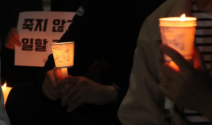 20일 오후 서울 중구 신당역 앞에서 열린 '신당역 스토킹 살인사건 희생자를 위한 추모 문화제'에서 참가자들이 '죽지 않고 일할 권리' 등이 적힌 피켓과 함께 촛불을 들고 있다. (사진/뉴시스)